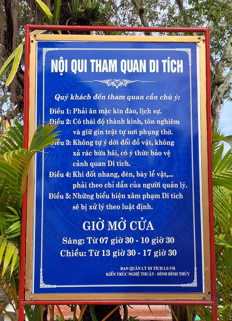 Biển báo nội quy tham quan di tích Đình Bình Thủy màu xanh dương khung đỏ, ghi chi tiết 5 điều quy định và khung giờ mở cửa.
