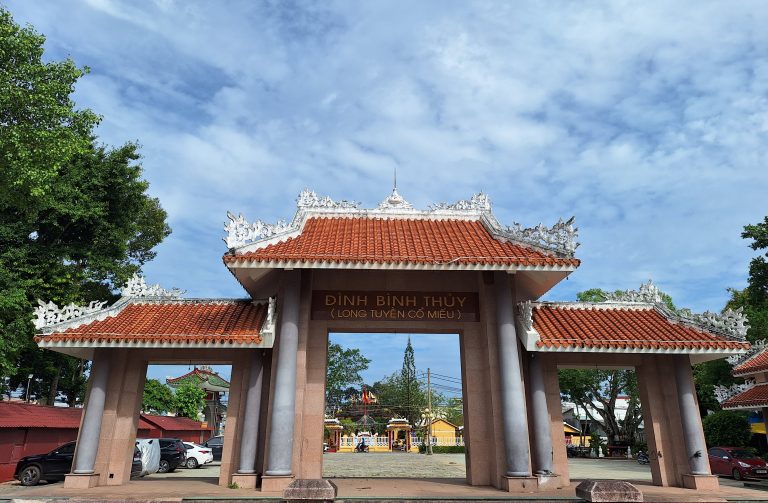 Cổng tam quan lớn dẫn vào Đình Bình Thủy lợp ngói đại bản màu đỏ, bảng hiệu trung tâm khắc dòng chữ "ĐÌNH BÌNH THỦY (LONG TUYỀN CỔ MIẾU)".