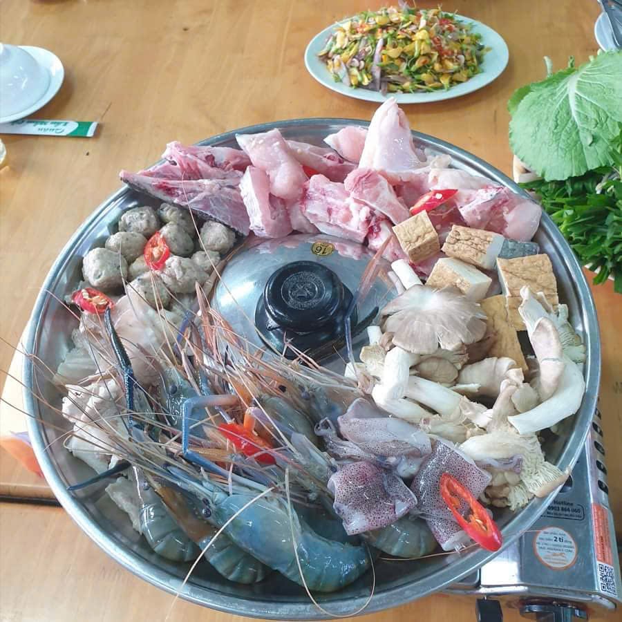 Mâm topping lẩu mắm tại một quán ăn Cần Thơ bao gồm tôm càng xanh, mực tươi, cá viên, cá hồi, các loại nấm và đậu hũ được bày biện bắt mắt trên vành nồi lẩu.